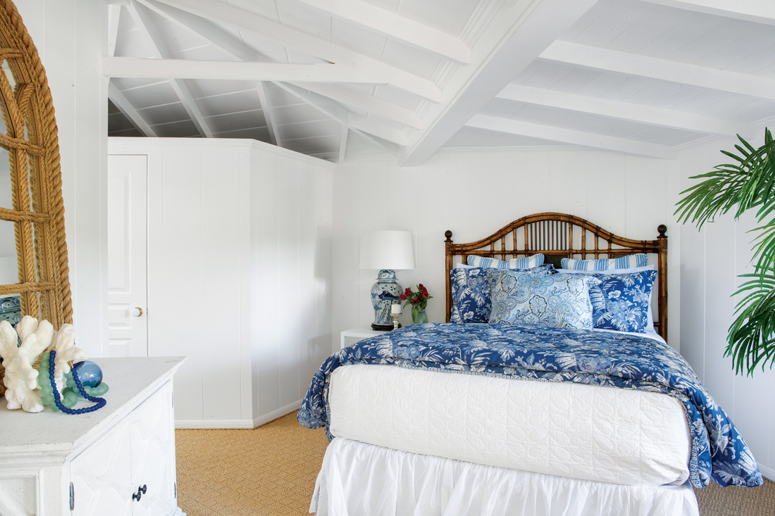 White vaulted ceilings in the lovely bedroom with cobalt blue accents.