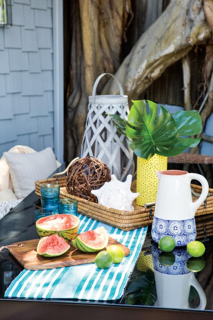 Outdoor table set up for entertaining guests with fresh fruit and beverages.