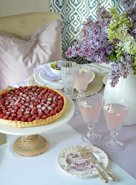 raspberry tart and pink lemonade on a pretty table with lilacs