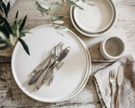 Stoneware plates, bowls and a cup photographed from above. 