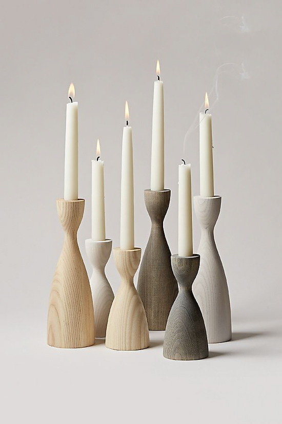 Ombre shaded wooden candlesticks from light wood to gray tone all with white candles lit in them