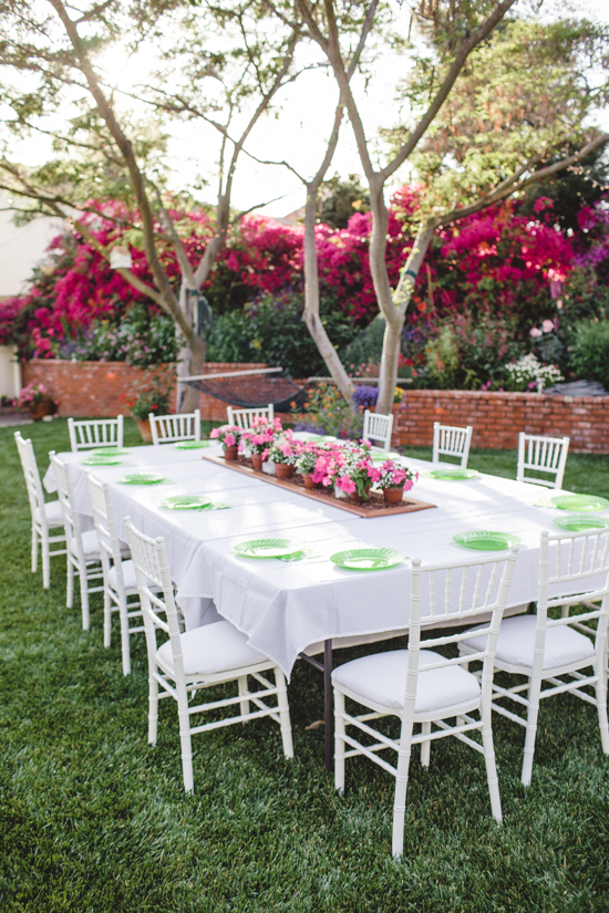 Outdoor table set for guests overlooking a hammock and bougainvillea.