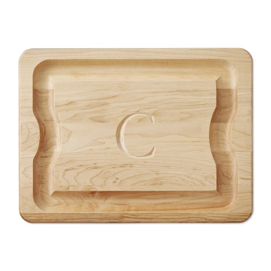 Hand carved wooden cutting board with a monogrammed initial C in the center