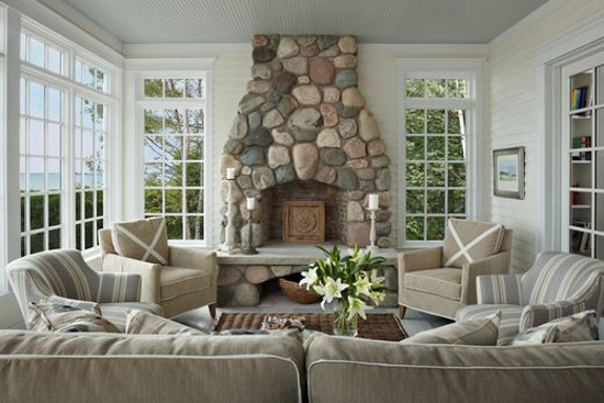 Cozy and light colored living room with a stone fireplace