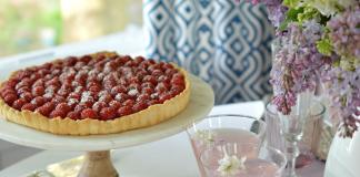 raspberry tart and pink lemonade on a pretty table with lilacs