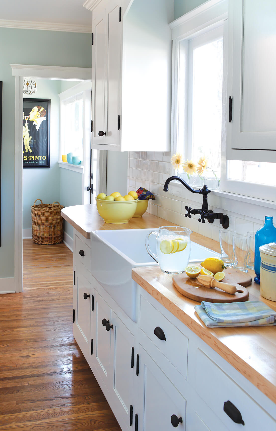 Kitchen with white inlay cabinets and butcher block, wooden countertops. 