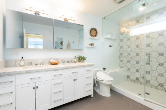 Gold and silver fixtures pop in the sparkling white bathroom with marble countertops.