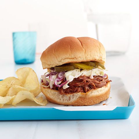 a brown bun holds together juicy brisket and crisp coleslaw