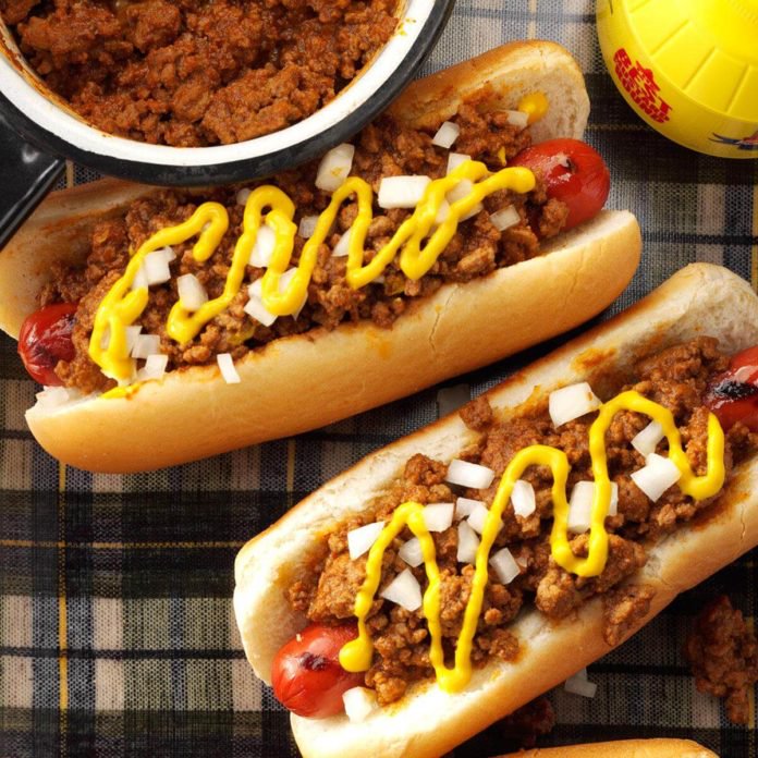 ground beef and mustard are slathered over grilled hot dogs