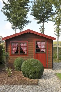 small house with round boxwood hedges