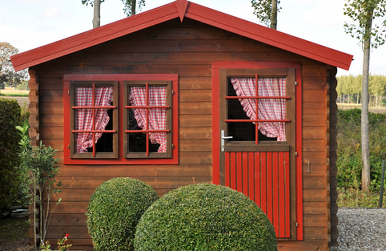 red house with round boxwood shrubs