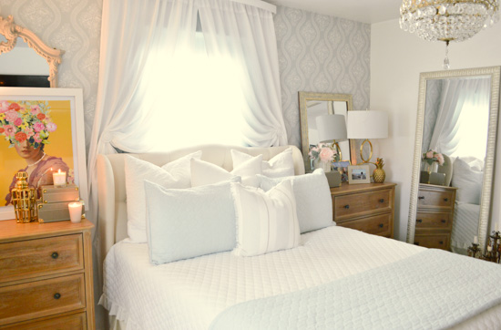 Cozy and inviting bed with white and powder blue accents. 