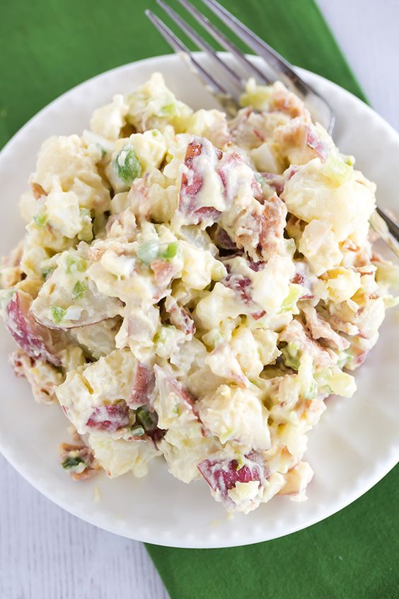 red-skinned creamy potatoes mixed with chives sit in a bowl