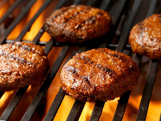 burger patties sit on a fired-up grill 