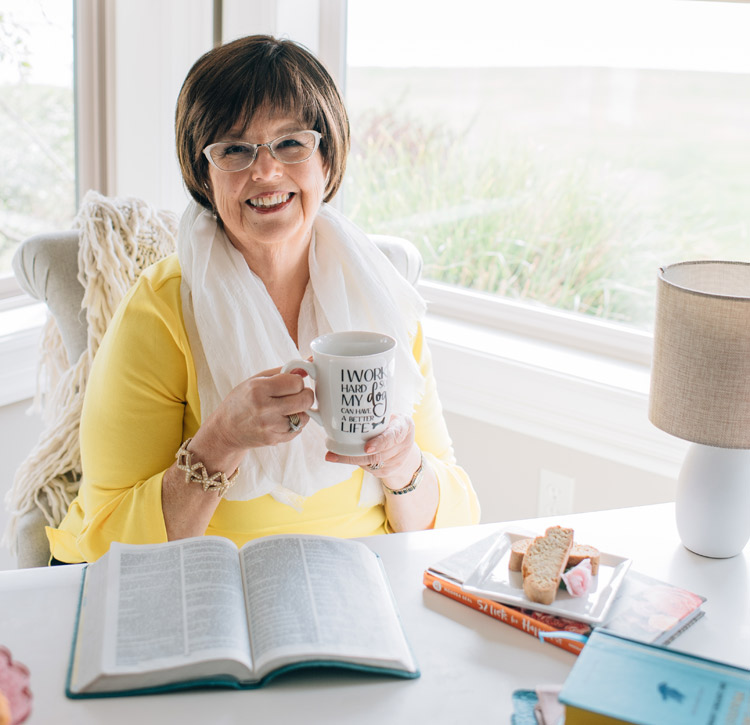 Debbie Macomber sits at a desk