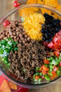 taco meat and toppings sit unmixed in a bowl
