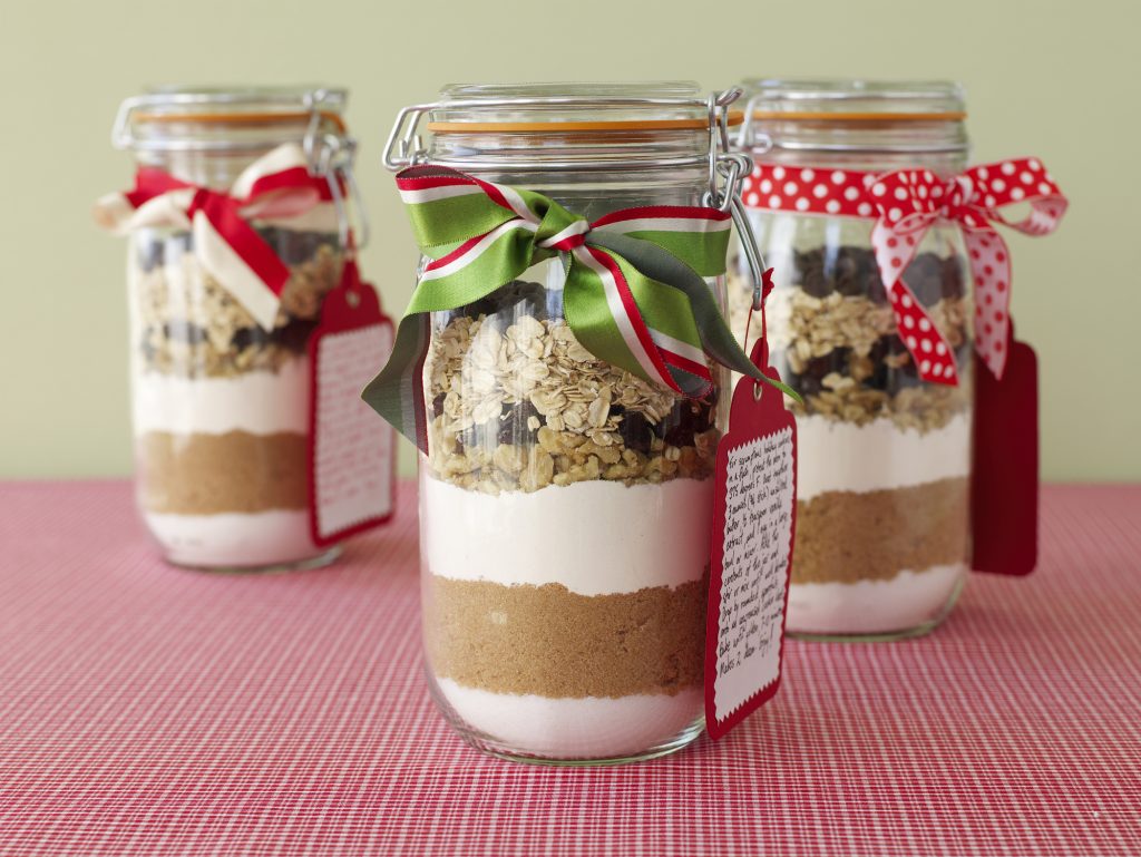 cookie ingredients nicely layered in a jar topped with christmas ribbon and a recipe tag