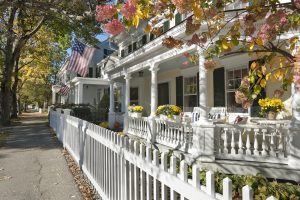 row of small historic homes with white picket fence