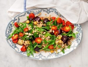 grilled vegetables and greens mixed with rice in a bowl