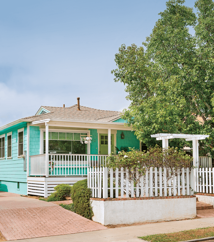 White picket fences and a bright blue exterior bring this charming beach cottage to life.