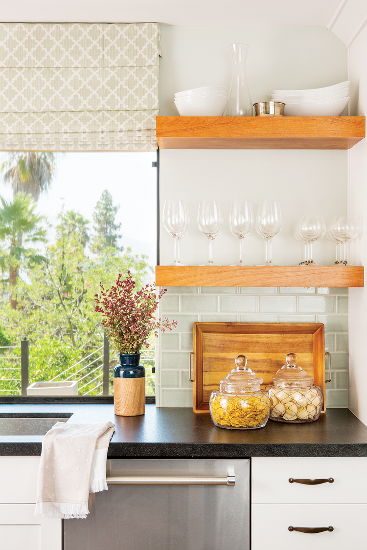 Light and airy backdrop that suits this open shelving with a pop of bold back granite countertops.