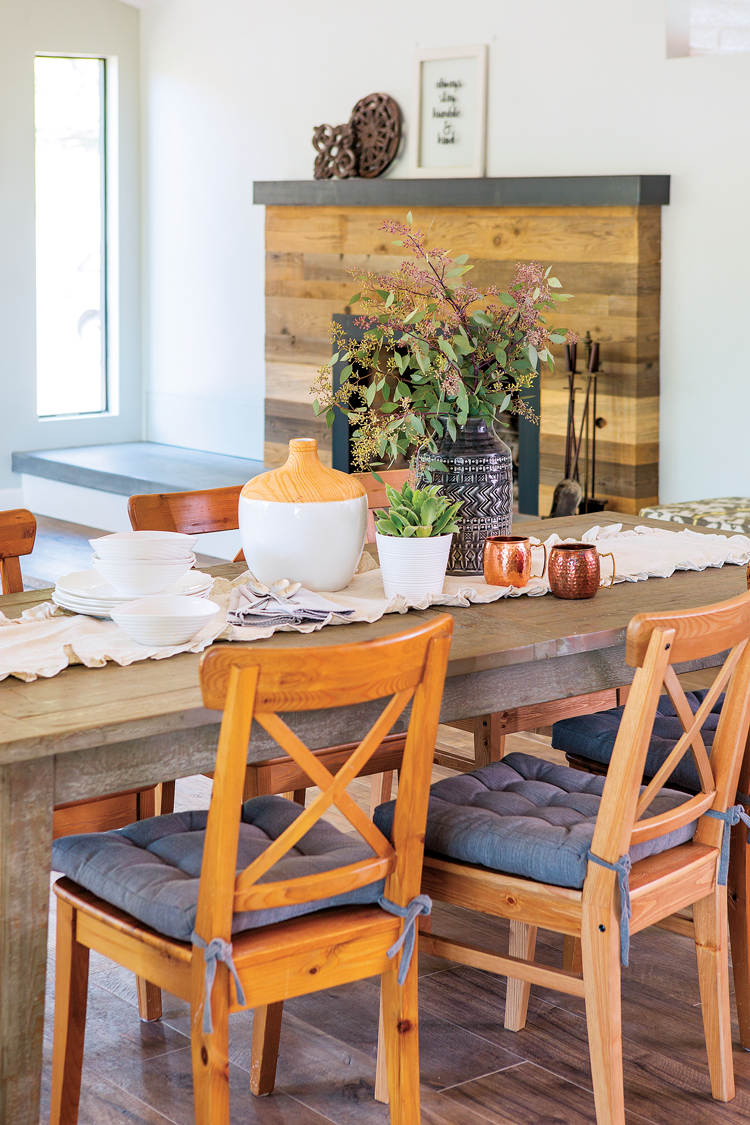 A view from the open-concept kitchen that spans across the rustic dining table and into the living space. 