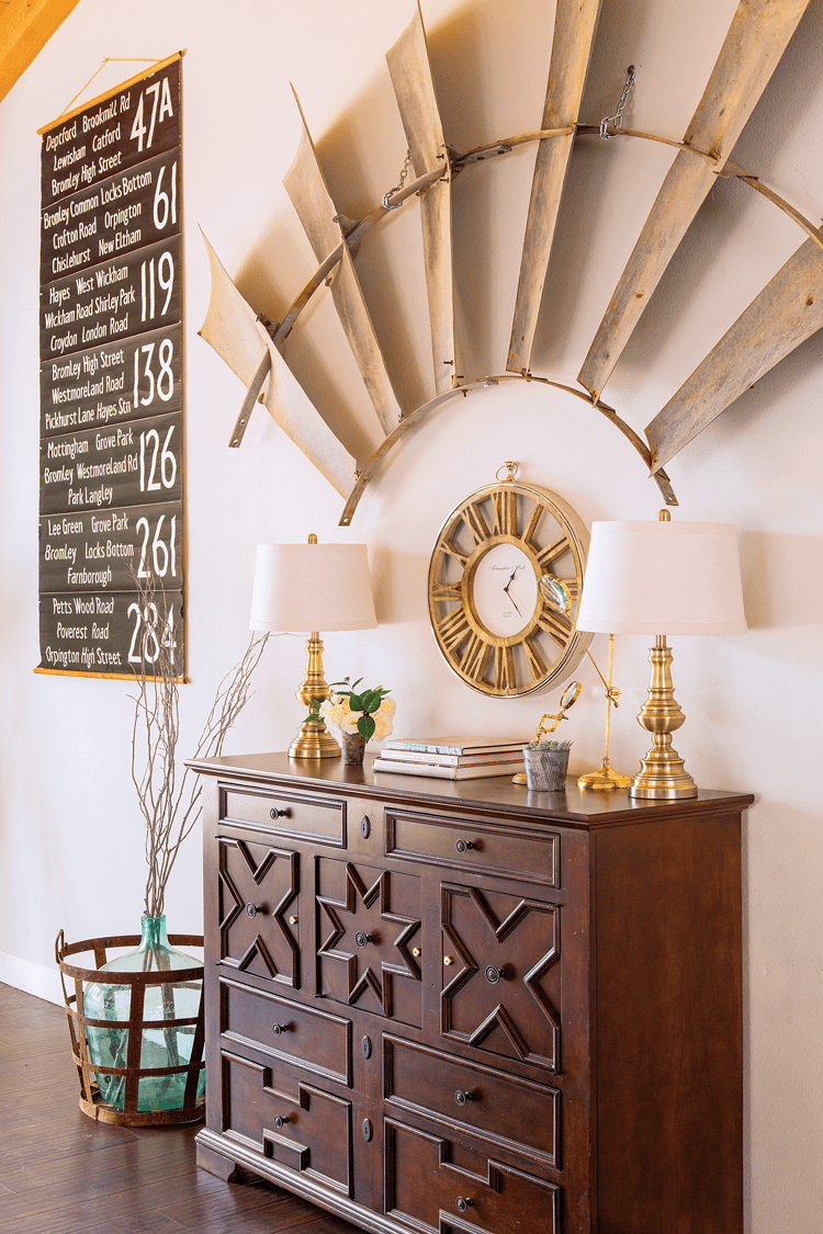 Antique London bus station signs frame the aluminum windmill segment that is the focal point on a large wall.