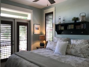 a beach- themed bedroom with white and grey bedding