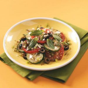A bowl of vegetables sits on a yellow table