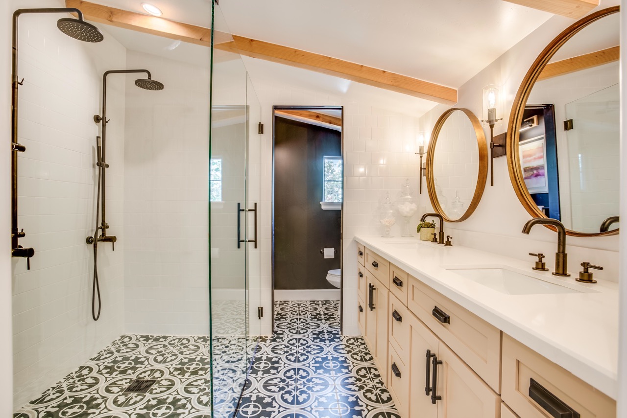 two shower heads hang over elegant floor tiling