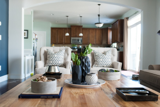 Looking over the coffee table and arm chairs into the open concept kitchen from the living room. 