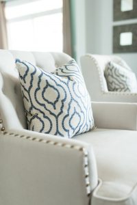 Lovely cream armchairs with blue and white accent pillows.