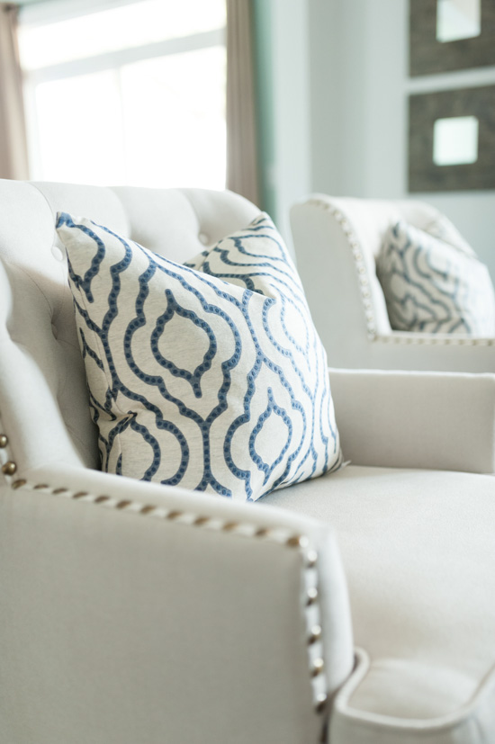 Lovely cream armchairs with blue and white accent pillows. 