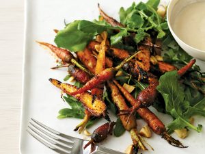 Roasted carrots and greens on a plate.