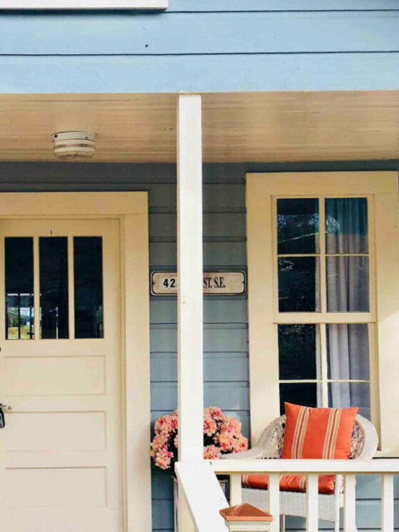 Bright blue cottage with cream door and pink flowers