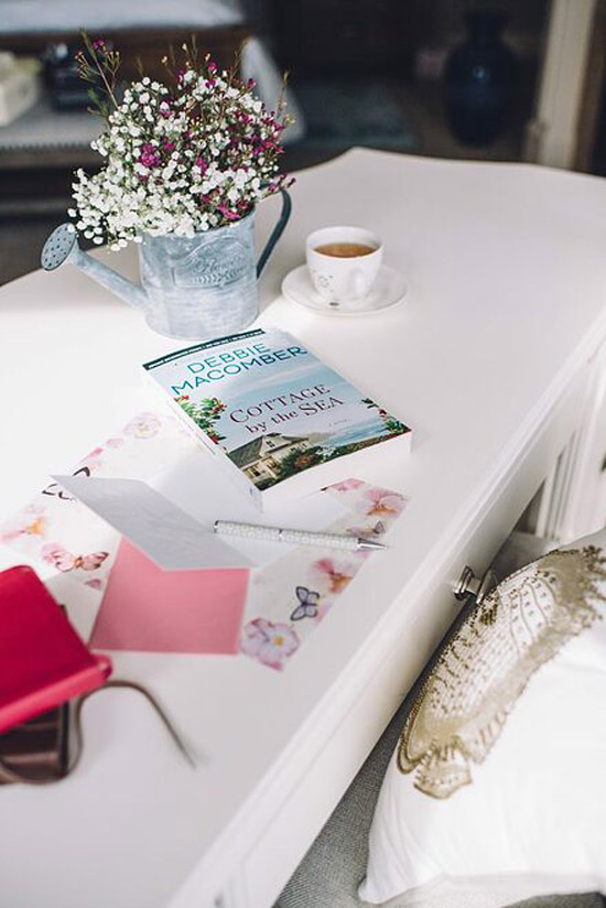 book and card and coffee cup sits on top of desk