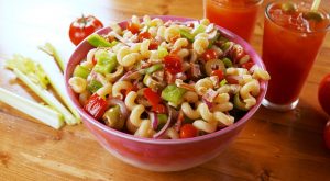 Pasta salad in a pink bowl.