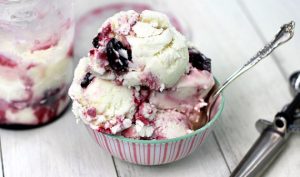 cherry and vanilla ice cream in a striped bowl