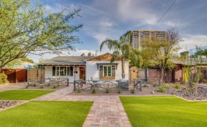 house with palm trees and stone pathway