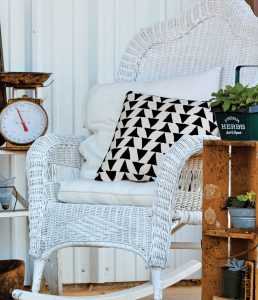vintage wicker chair with black and white pillow