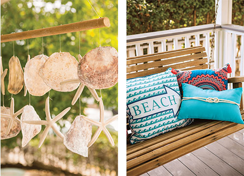 Hanging sand dollar and starfish wind chime and bright throw pillows on the wooden bench swing. 