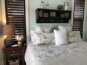 a beach- themed bedroom with white and grey bedding