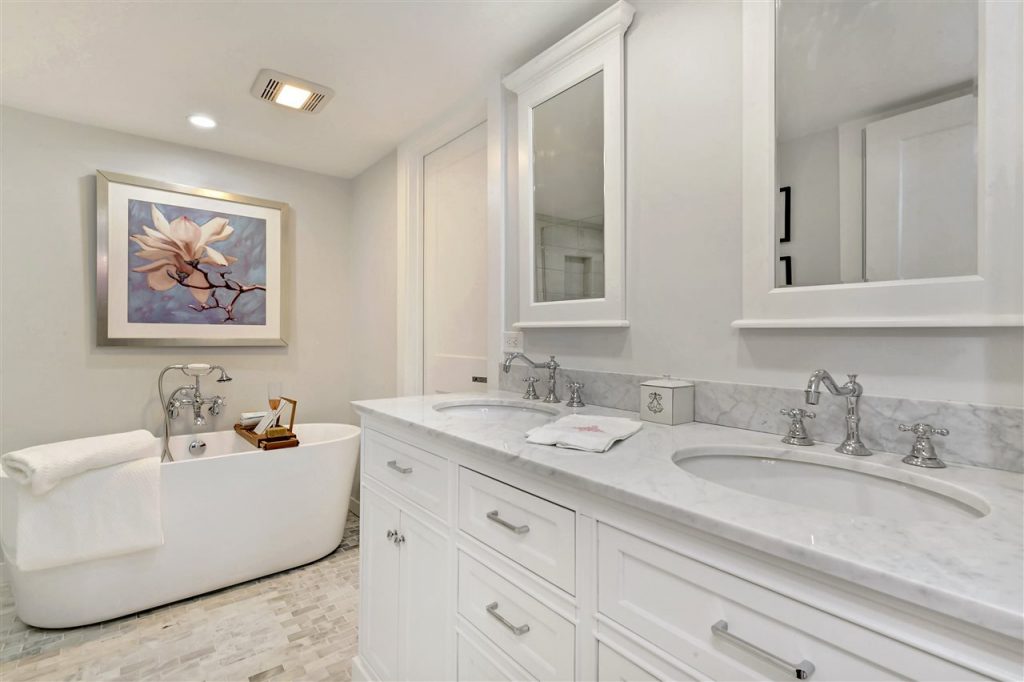 updated cottage master bath suite with modern freestanding tub, white carera marble tile floors and countertop