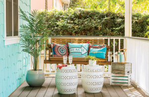 Charming beach cottage porch with wooden swing and bright colored accents.