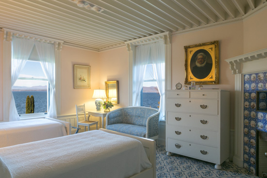 Interior shot of the Dutch Room at the Inn at Shelburne Farms, decorated in white and light blue. 