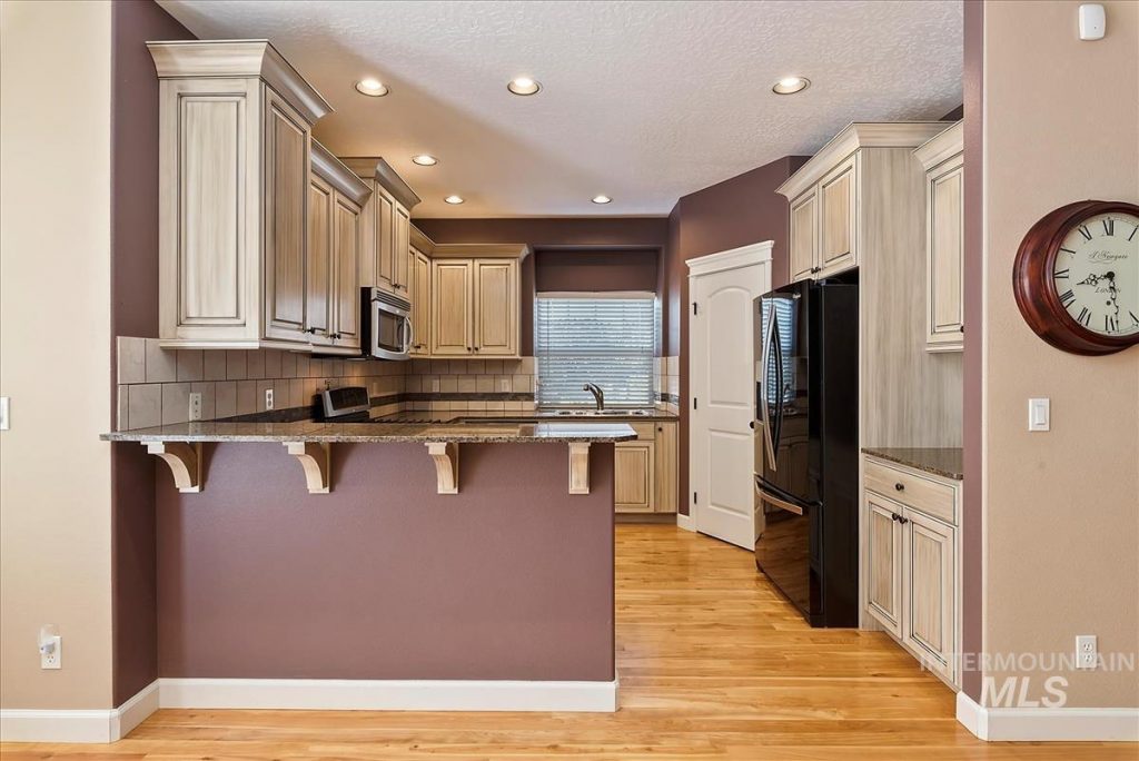 small kitchen with cream cabinets and bar counter