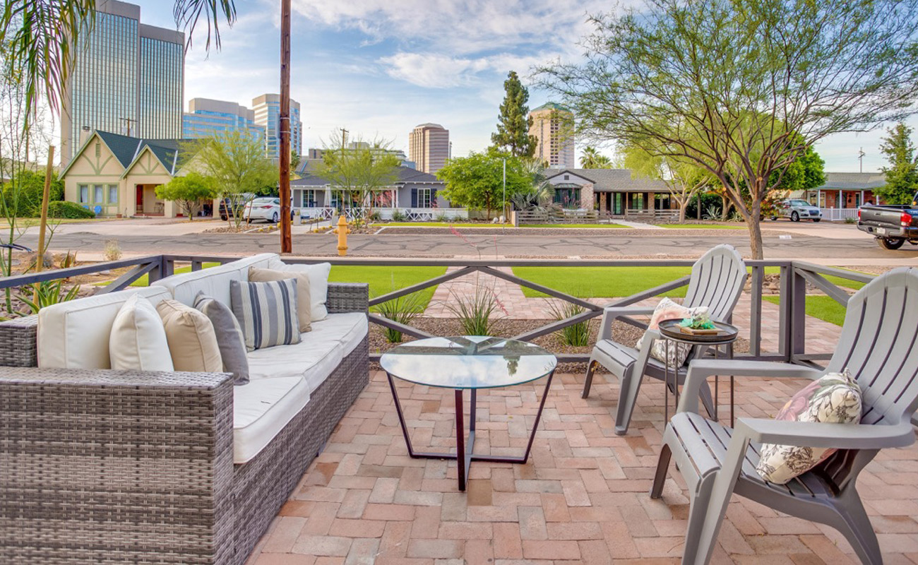 grey lawn chairs with glass table and white and brown couch