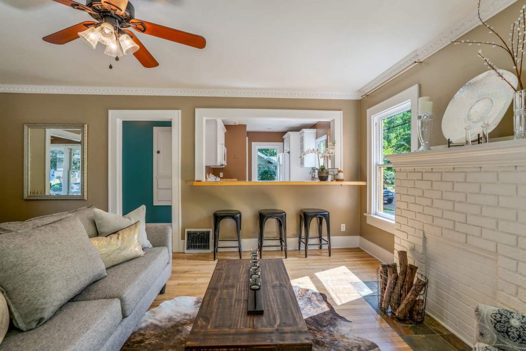 craftsman cottage living room with brick fireplace and passthrough kitchen window