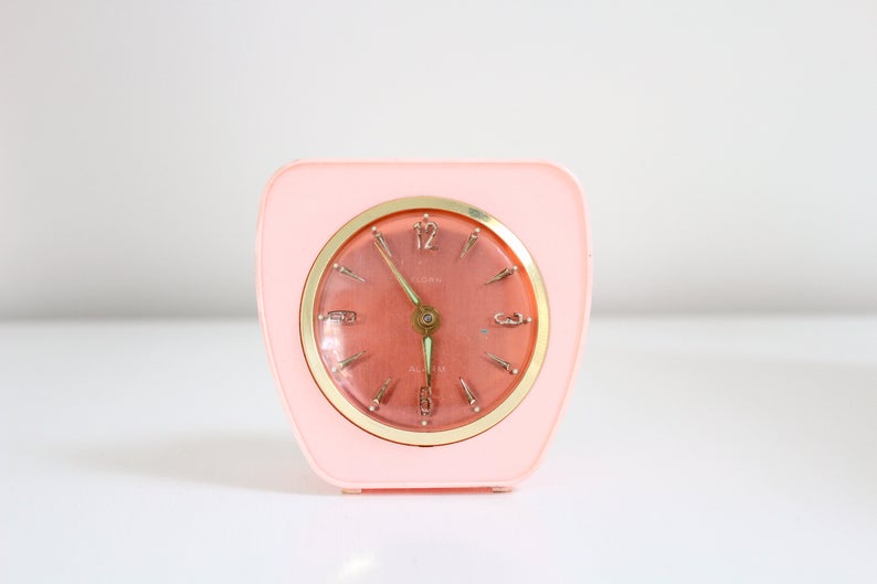 Retro pink plastic alarm clock with gold detailing.