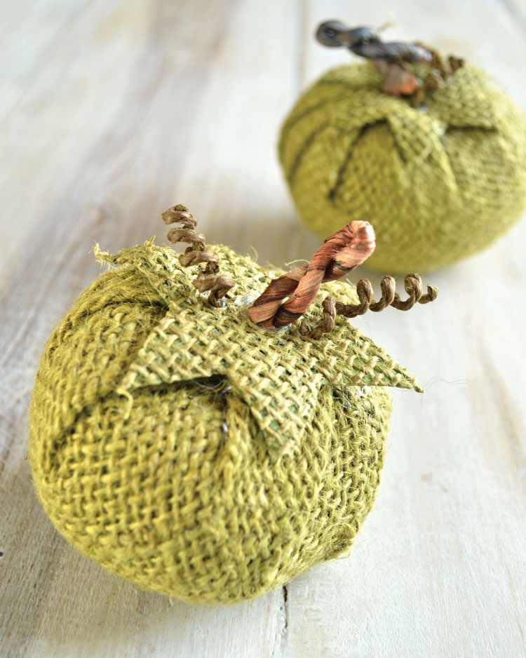 Two small decorative gourds made out of burlap and raffia-wrapped wire. 